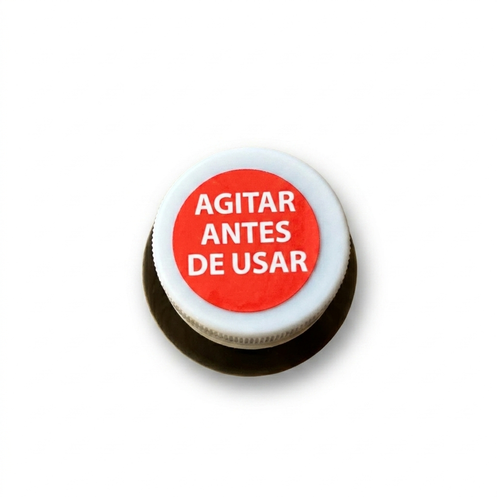 Perspectiva superior e inclinada del frasco de Naxpet 20 ml de Drag Pharma sobre fondo blanco, enfocando la tapa y el cuello de la botella con el mensaje "Agitar antes de usar" sobre un fondo rojo circular.